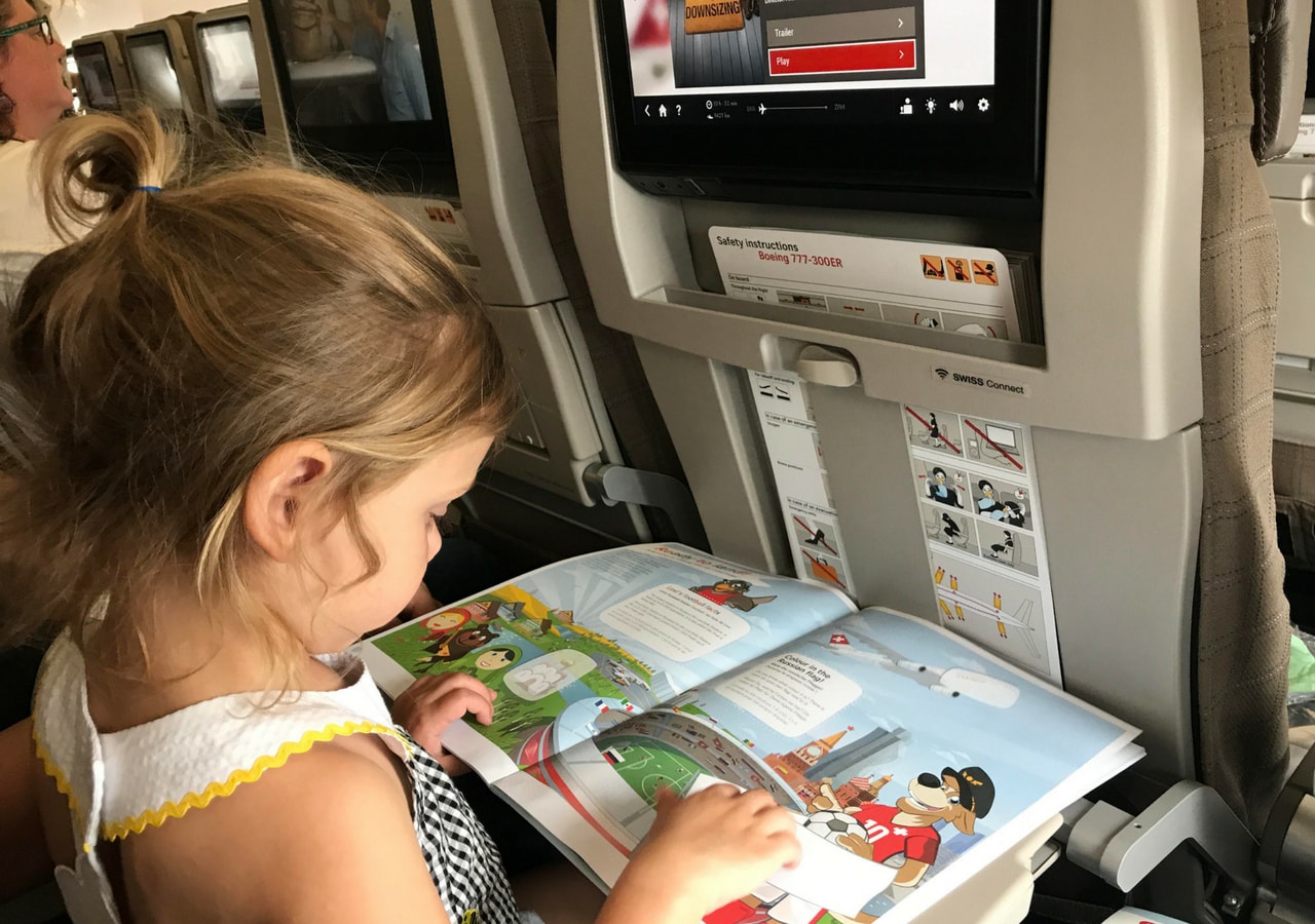 toddler entertaining herself in flight on a Swiss Airlines flight