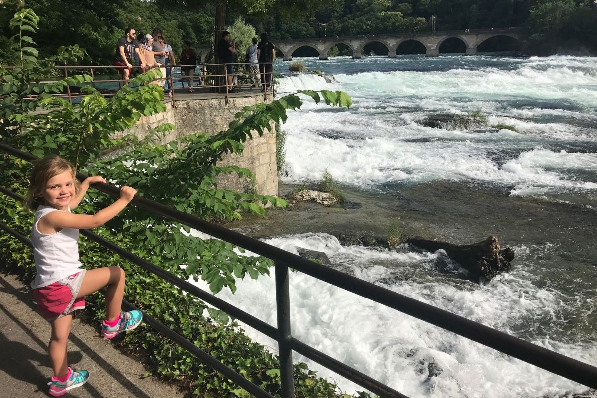 Rhine Falls with kid standing nearby