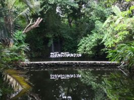 Sampran Riverside sign in thai with a waterfall behind