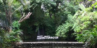 Sampran Riverside sign in thai with a waterfall behind