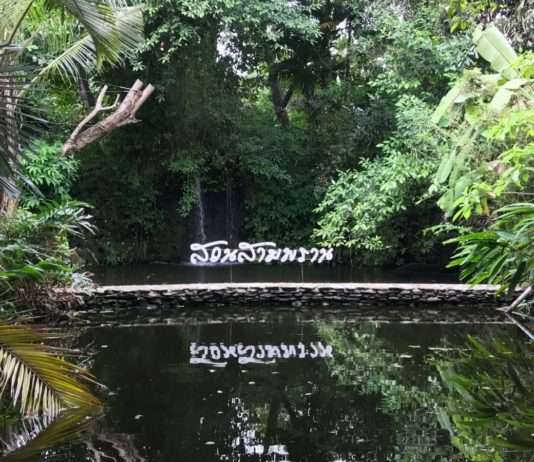 Sampran Riverside sign in thai with a waterfall behind